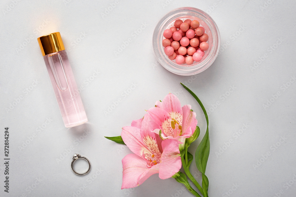 Decorative cosmetics and flowers on light background Decorative cosmetics and flowers on light background