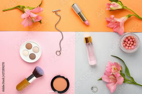 Decorative cosmetics and flowers on color background