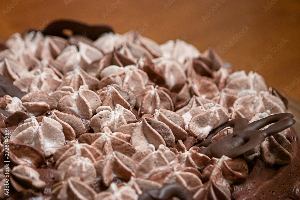 layers of varigated frosting swirled on top of a thin single layer coffee flavored cake set on a table in a kitchen layers of varigated frosting swirled on top of a thin single layer coffee flavored cake set on a table in a kitchen