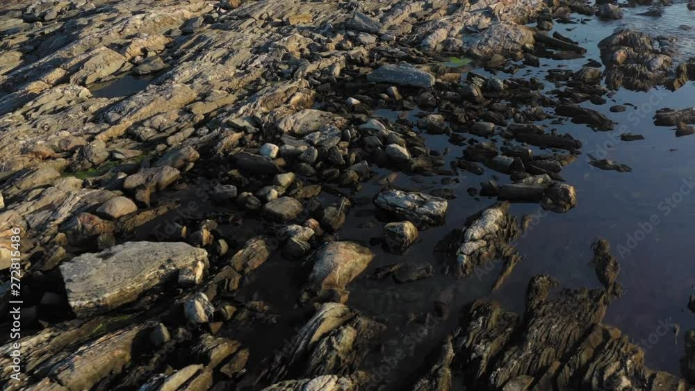 Curving over a rocky tidal pool on coastal Maine AERIAL TOPDOWN Curving over a rocky tidal pool on coastal Maine AERIAL TOPDOWN
