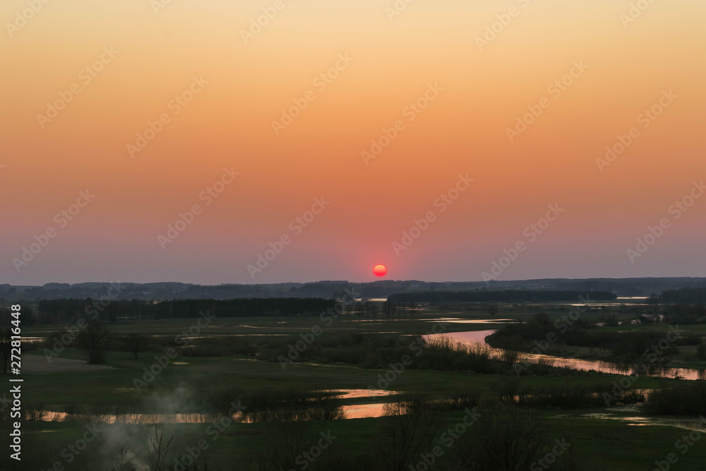 Magical landscape of the setting sun over the river valley.