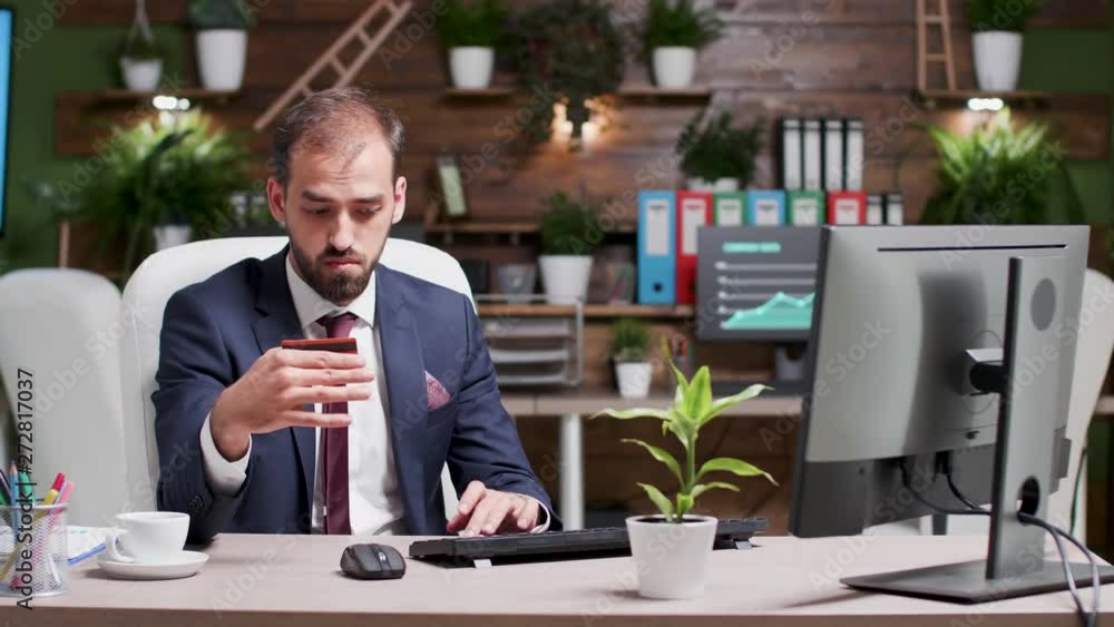 Male in business suit entering credit card information in the computer for an online purchase Male in business suit entering credit card information in the computer for an online purchase