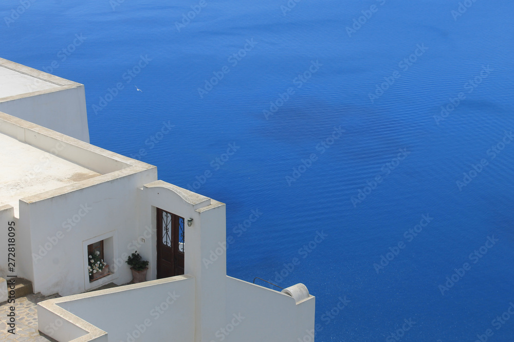 Obraz premium Spectacular sea view with white traditional cycladic building. Big blue space for text. Perfect background for all purpose prints. Santorini oia fira caldera view.