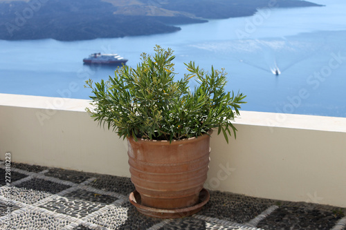 Terracote flower pot by the sea landscape view. Mediterranean floral greece santorini background with free space for text.