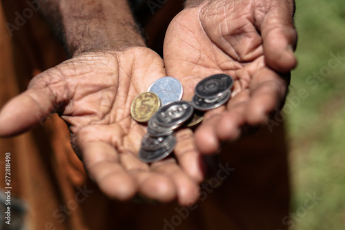 Coins in dark working hands. Beyond the poverty line in Asian countries. Subject soap bar.