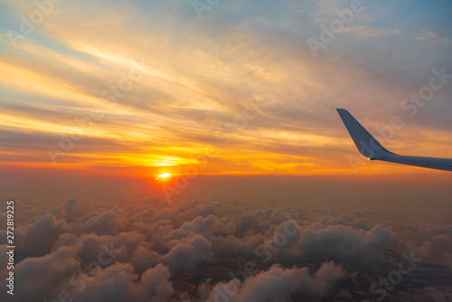 Wing of the air plane on the sea of cloud sunset sky background from window airplane © lukyeee_nuttawut