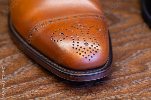 Foto brown brogue toe of men full grain leather shoe, close up
