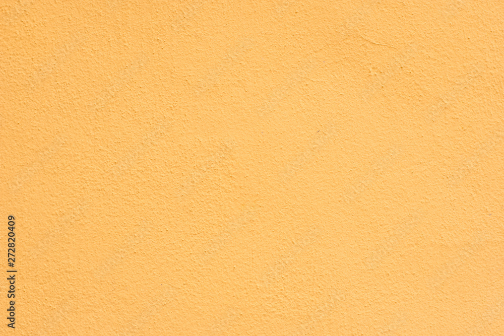Background of a yellow stucco coated and painted exterior, rough cast of cement and concrete wall texture Background of a yellow stucco coated and painted exterior, rough cast of cement and concrete wall texture