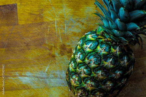 Pineapple fruit on top of wooden table photo