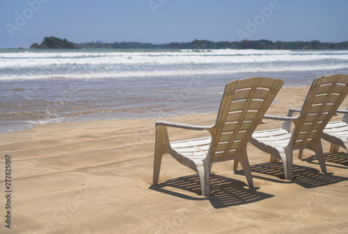 Beautiful Sri Lankan view of the Indian Ocean with sun loungers on the beach. Summer holidays in Asia. Stock photos