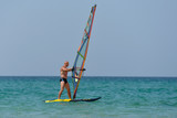 Sports man Windsurfing at sea on a Sunny summer day.