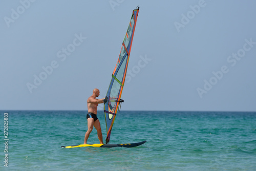 Sports man Windsurfing at sea on a Sunny summer day.