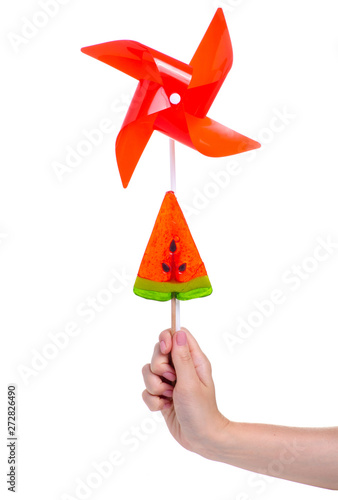 Candy and toy windmill in hand on white background isolation