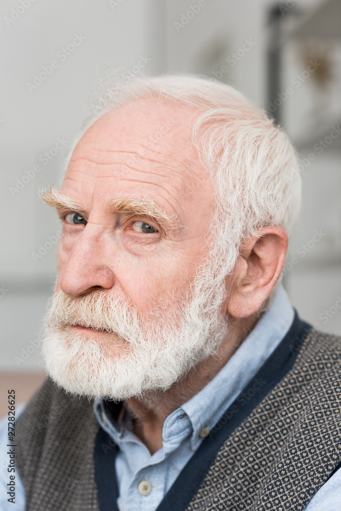 Sad and bearded grey haired man looking at camera Sad and bearded grey haired man looking at camera