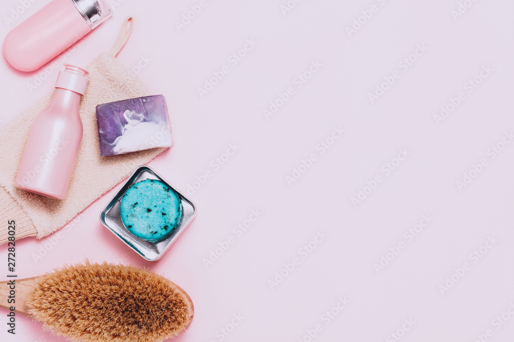Spa cosmetic background. Bottles, body brush and tropic leaves on pink background. Top view, flat lay. Spa cosmetic background. Bottles, body brush and tropic leaves on pink background. Top view, flat lay.