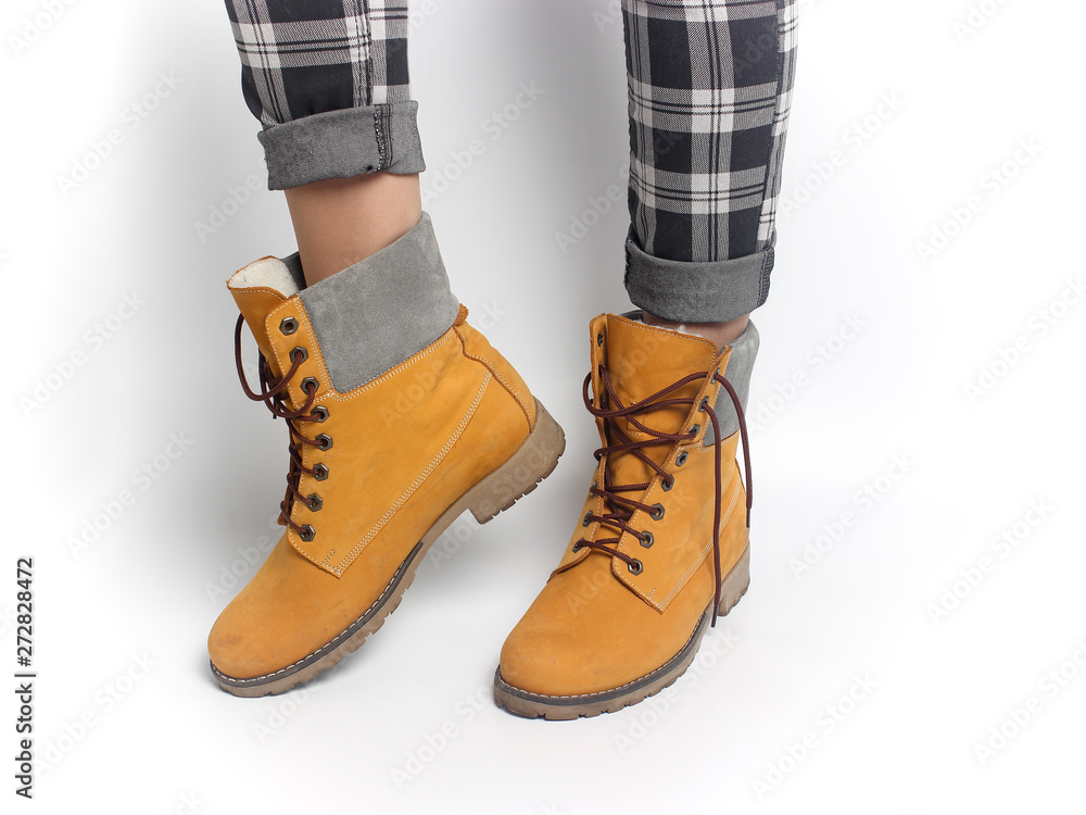 Women's legs in yellow shoes and checkered pants. Winter clothes. Women's legs in yellow shoes and checkered pants. Winter clothes.