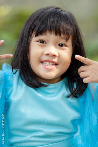close up face asian girl children toothy smiling face happiness emotion looking to camera photo