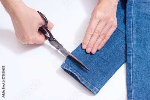 Woman hands Hemming Denim with scissors