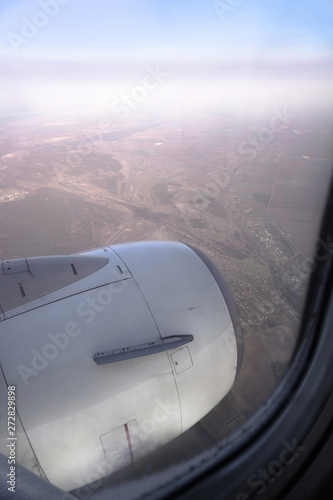 View from the airplane window on the river below. Tourist route to warm countries. The theme of the travel agency. Stock photo