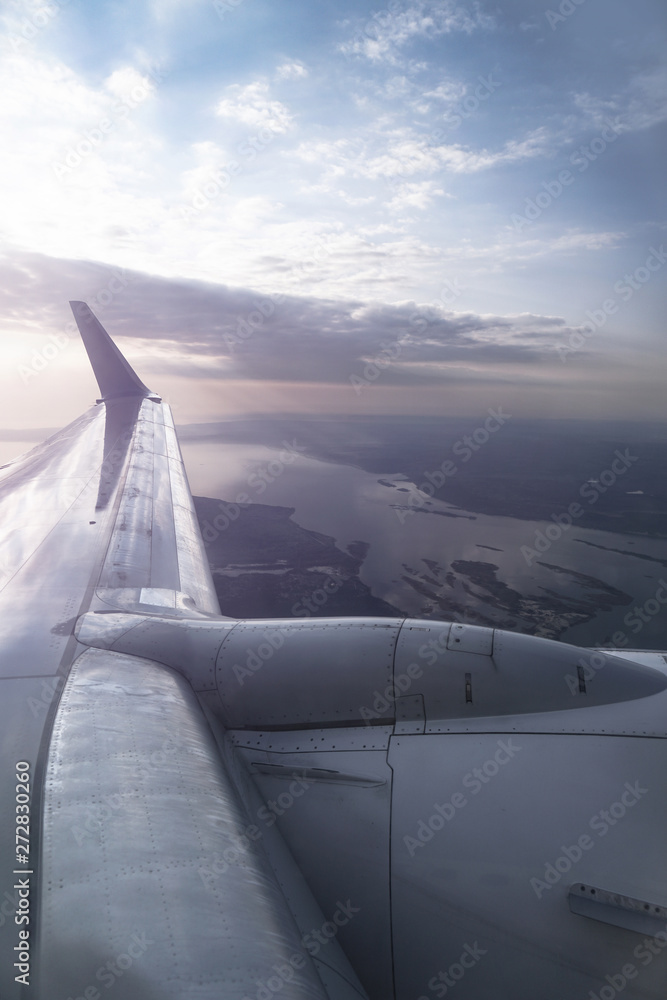 Fototapeta premium View from the airplane window on the river below. Tourist route to warm countries. The theme of the travel agency. Stock photo