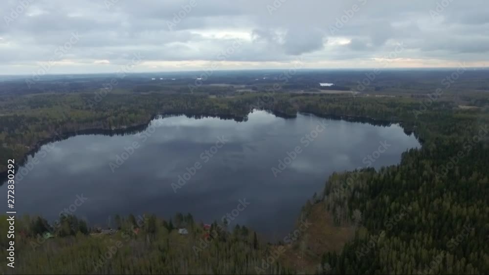 Aerial drone shot of forest and fields. Flying over Finland landscape. Cloudy day. Mirror surface lake water. Aerial drone shot of forest and fields. Flying over Finland landscape. Cloudy day. Mirror surface lake water.