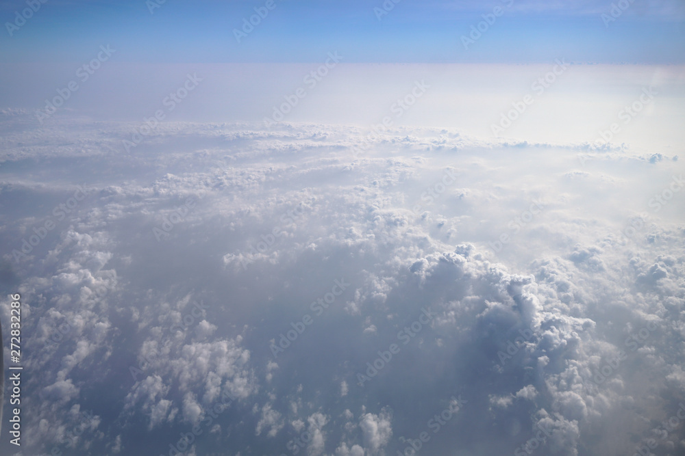 Airplane window overlooking the beautiful clouds and the earth. Sunset in flight on vacation. Tourist theme. Stock photo Airplane window overlooking the beautiful clouds and the earth. Sunset in flight on vacation. Tourist theme. Stock photo