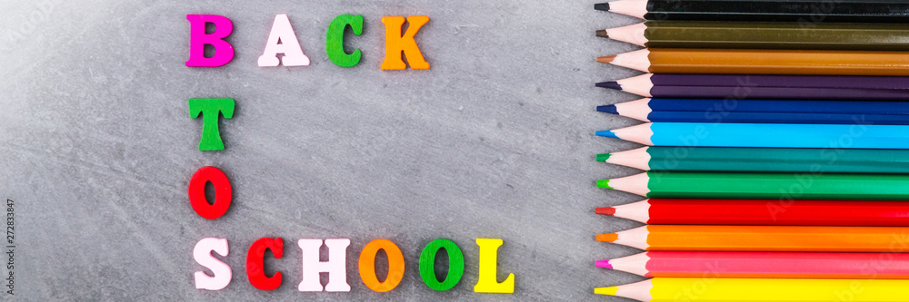 The layout of school supplies on a dark gray background. Top view, the sun's rays from the side. Flat lay. Back to school. The layout of school supplies on a dark gray background. Top view, the sun's rays from the side. Flat lay. Back to school.