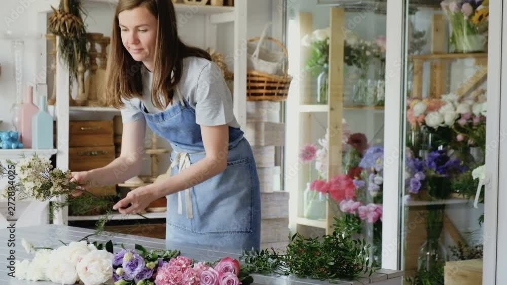 Charming young woman sorts beautiful flowers to create a magnificent bouquet in the workshop. Concept design holidays and weddings Charming young woman sorts beautiful flowers to create a magnificent bouquet in the workshop. Concept design holidays and weddings