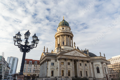 Old streetlight and Neue Kirche (Deutscher Dom, German Church or German Cathedral) in Berlin, Germany, at the Gendarmenmarkt Square in Berlin, Germany, on a sunny morning.