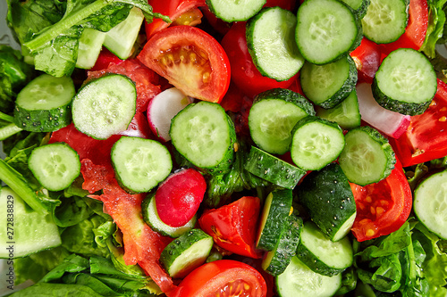 Vegetable fresh salad from tomatoes, cucumbers, greens, spinach, radishes. Fresh ecological salad. Healthy food. Textured salad