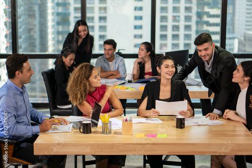 фотографія Group of young business people discussing in modern coworking space
