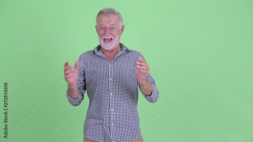 Happy senior bearded man looking around and feeling excited Happy senior bearded man looking around and feeling excited