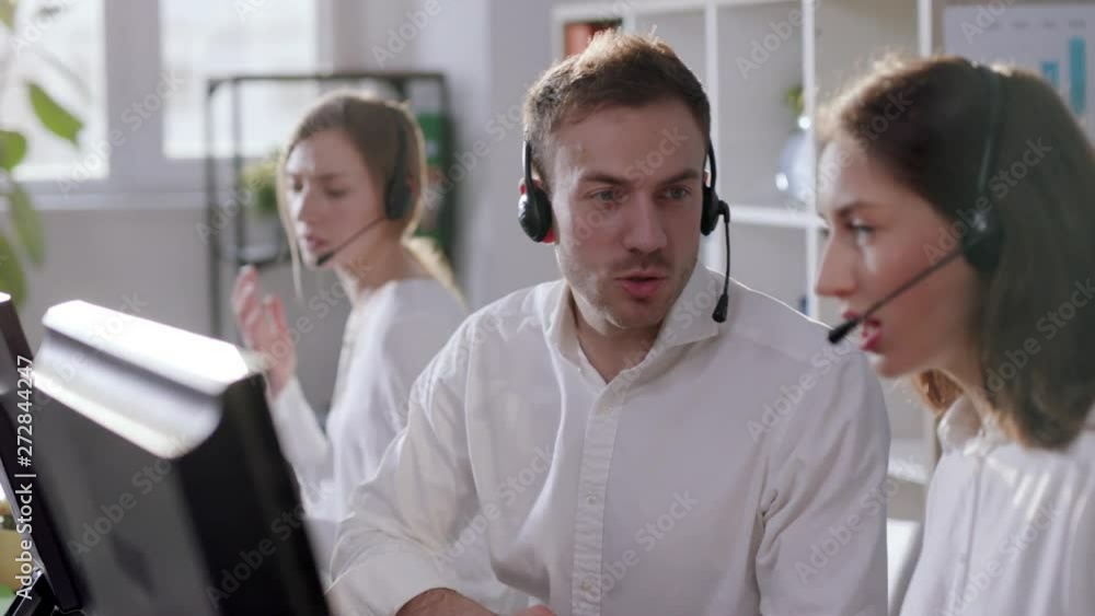 Group of young people operator talk woman man in busy call center office business worker computer corporate headset job man service group finance sunshine phone slow motion Group of young people operator talk woman man in busy call center office business worker computer corporate headset job man service group finance sunshine phone slow motion