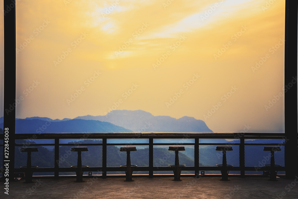 Old wooden chair with high sunrise view on the mountain