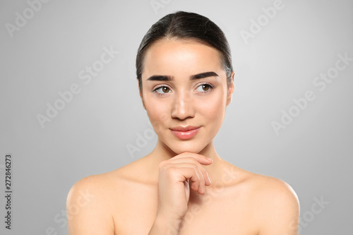Portrait of young woman with beautiful face against color background