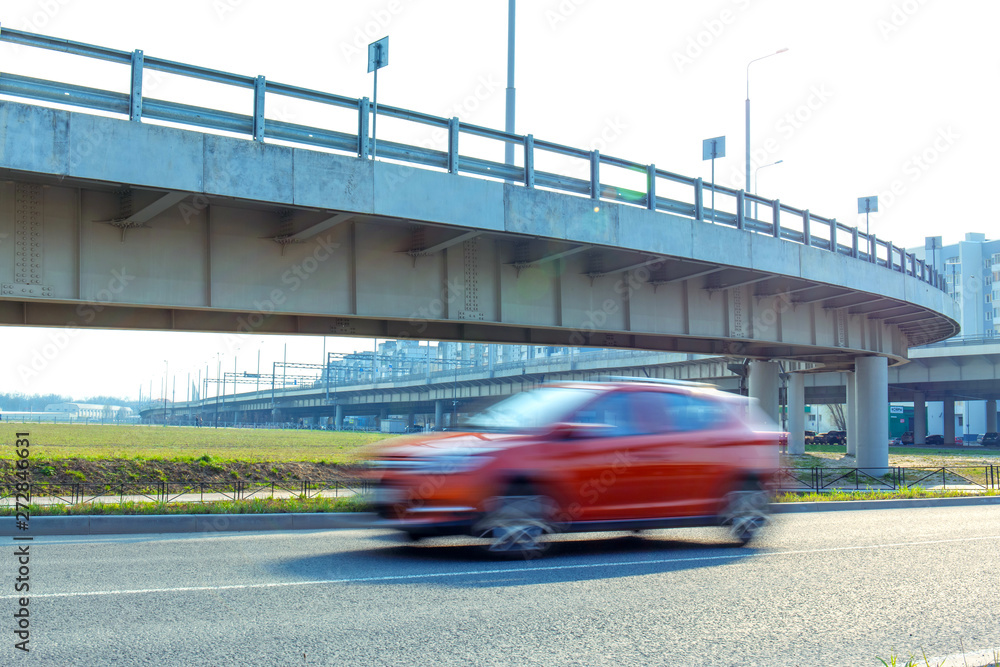 fast moving blurred red car on the background of a trestle bridge