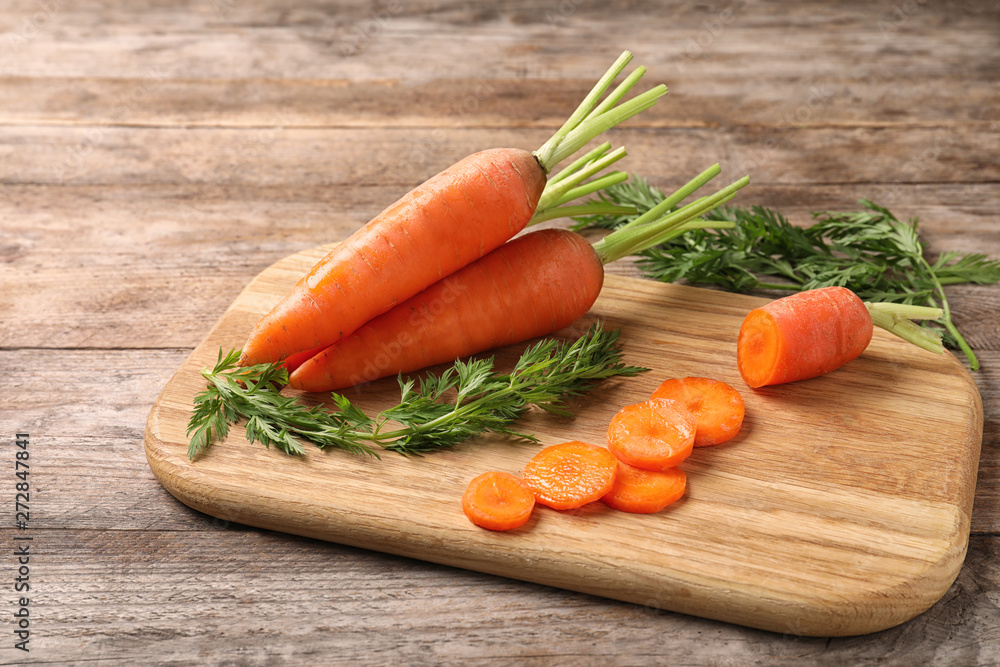 Board with cut carrot on wooden background Board with cut carrot on wooden background
