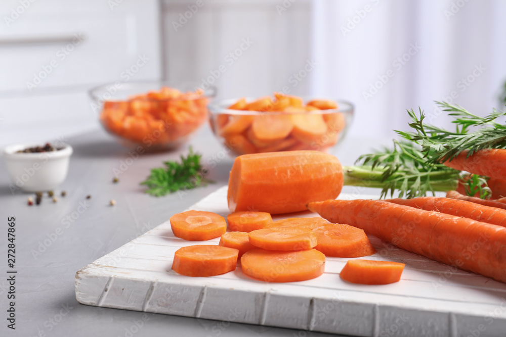 Board with slices of carrot on table Board with slices of carrot on table