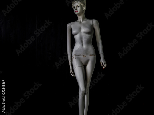 old dirty mannequin on a black background