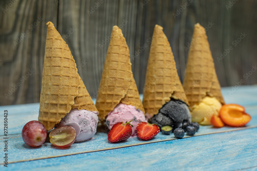 Sweet ice cream in balls in a waffle cone. Different flavors berries and fruits