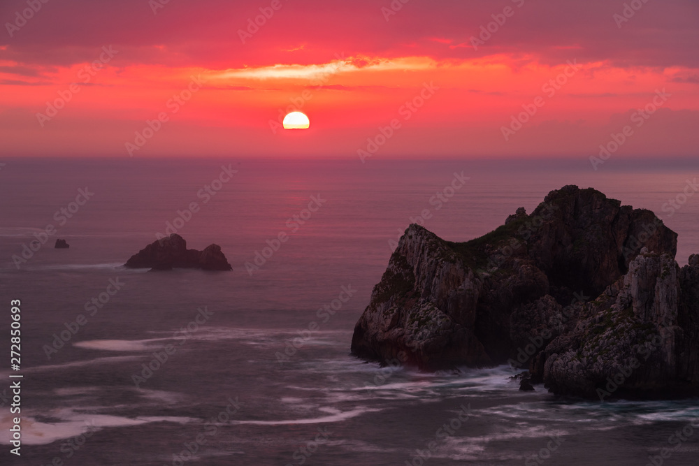 Beautiful Sunset at the rugged rocky coast of Liencres with Urros and clouds, Northern Spain