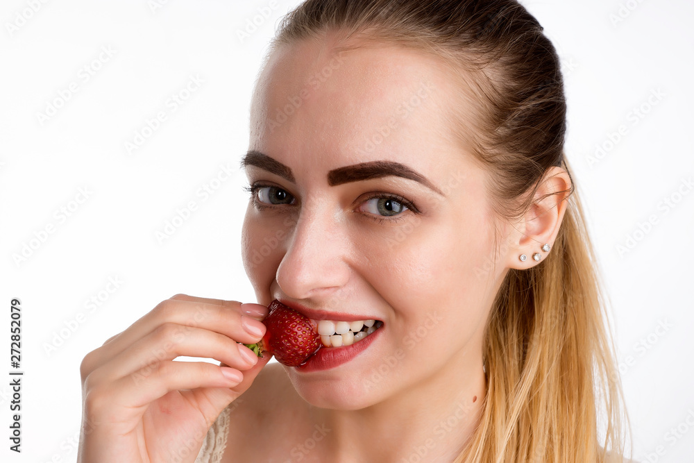 girl eagerly eating strawberries on white background. girl eagerly eating strawberries on white background.