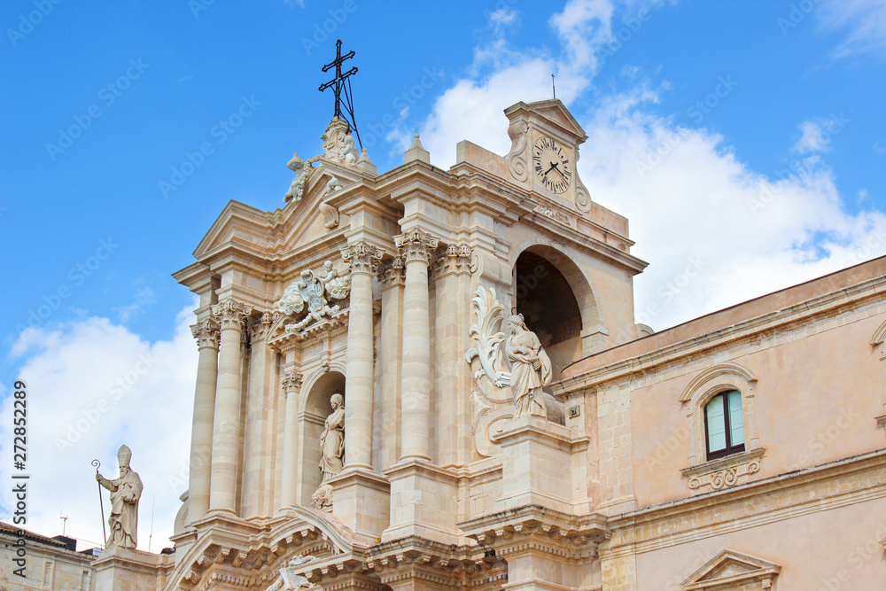 Detail of beautiful Syracuse Cathedral on Piazza Duomo Square with blue sky. Baroque architecture, medieval sculptures. Religious temple. Cross. Taken in Ortigia Island, Syracuse, Sicily, Italy