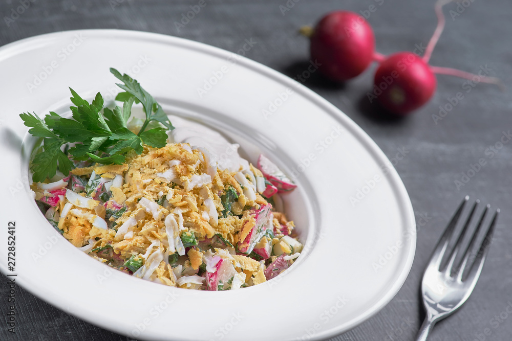 Fresh mixed salad with eggs, salad leaves and other vegetables, served on a plate on a dark background. Fresh mixed salad with eggs, salad leaves and other vegetables, served on a plate on a dark background.
