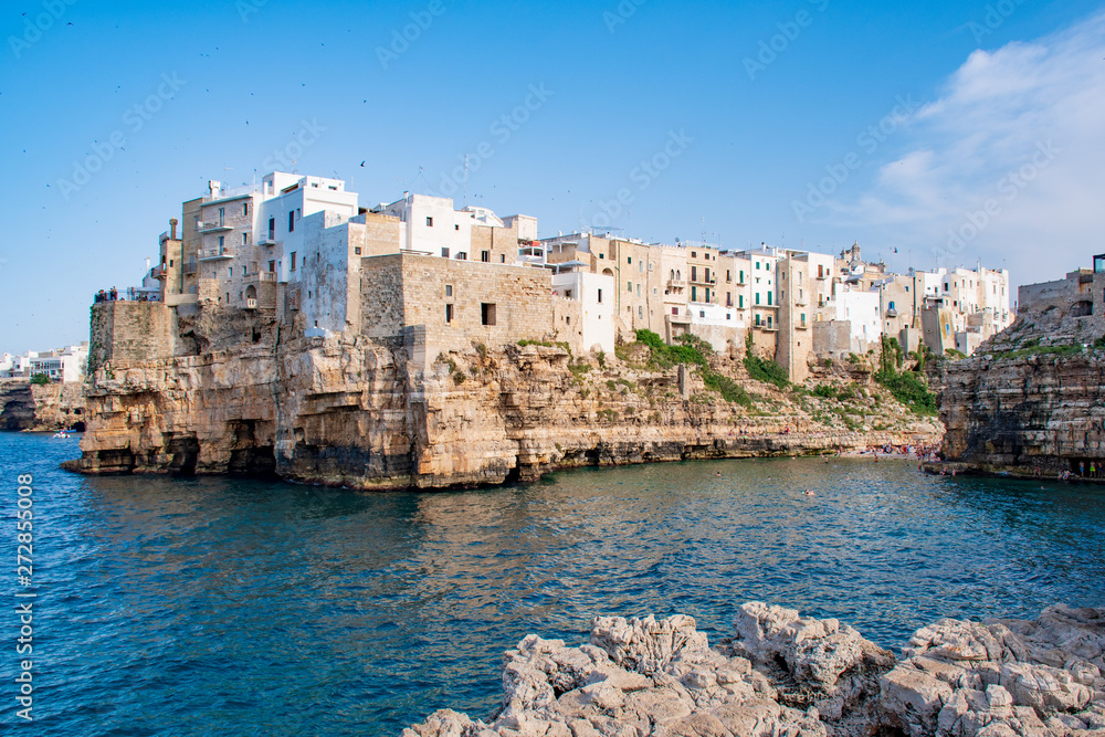 Panoramic city skyline with white houses of Polignano a Mare, town on the rocks, Puglia region, Italy, Europe. Traveling concept background with blue Mediterranean sea