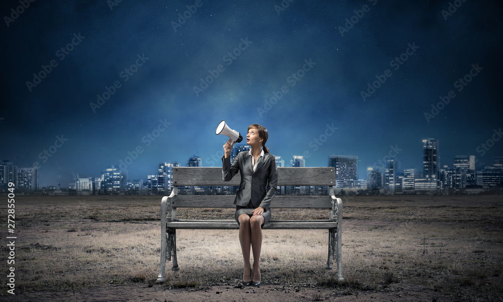 Business woman with megaphone on wooden bench Business woman with megaphone on wooden bench