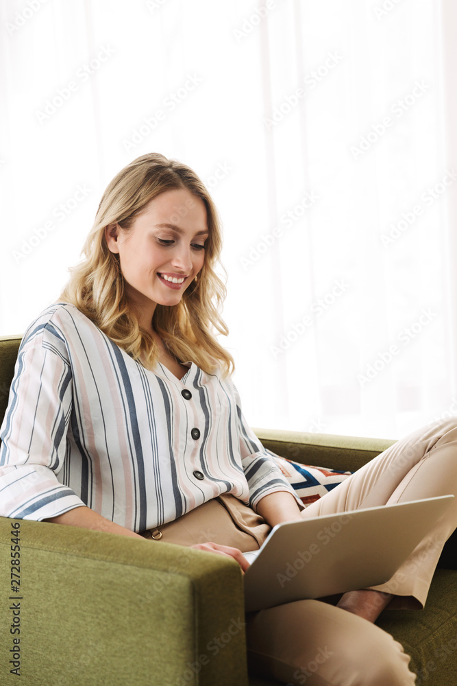 Beautiful young blonde woman sitting in armchair Beautiful young blonde woman sitting in armchair