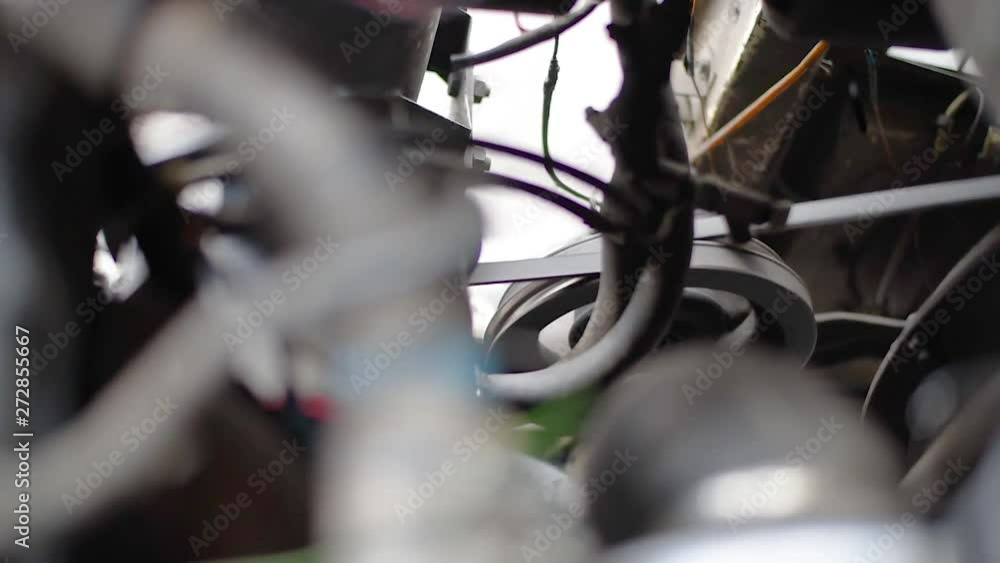 Timing belt alternator belt in motion on a running car engine. Car