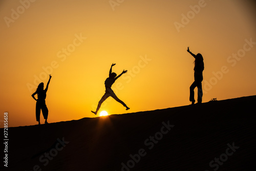 silhouettes of people on sunset background