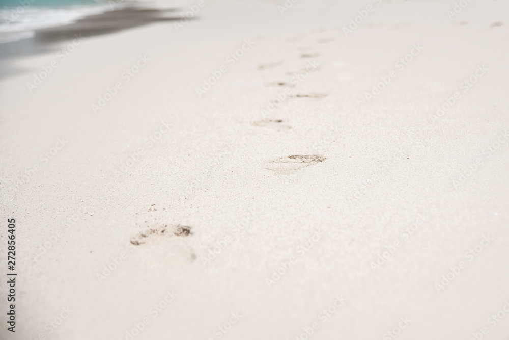 FOOTPRINTS IN THE SAND AT THE BEACH
